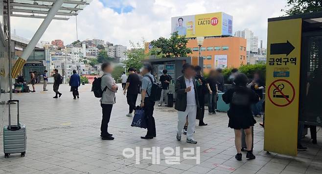 28일 서울역 광장에 마련된 금연구역 표지판 앞에서 시민들이 담배를 피우고 있다.(사진=염정인 기자)