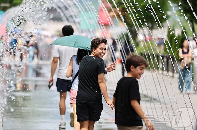 서울 종로구 광화문 광장을 찾은 관광객이 바닥분수에서 더위를 식히고 있다. /뉴스1 ⓒ News1 김도우 기자