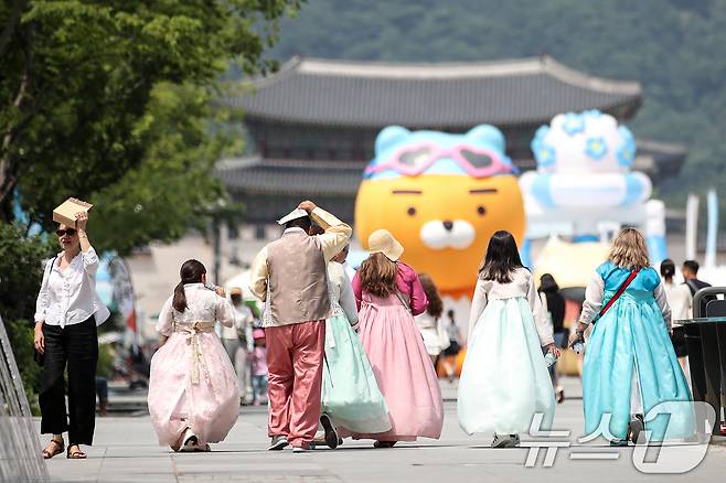 서울 세종대로 광화문광장에서 관광객과 시민들이 종이가방 등을 이용해 햇빛을 가리며 걷고 있다. /뉴스1 ⓒ News1 이승배 기자