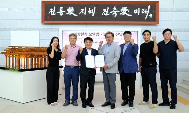 박승훈 캐디안 대표(왼쪽 세 번째)가 이성희 전통건축수리기술진흥재단 사무총장(왼쪽 네 번째)에게 인공지능(AI) 기술을 활용해 복원 설계·제작한 ‘불국사 법화전’ 미니어처를 전달한 후 참석자들과 파이팅을 외치고 있다.