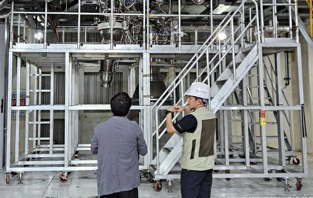 엔진시험평가팀 전준수 선임연구원(오른쪽)이 복잡하게 얽혀있는 연소설비를 가리키며, 설명했다.