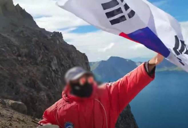 한국 유튜버의 태극기를 빼앗아 가는 백두산 중국측 관계자. 유튜브 채널 시수기릿 라이브 방송 캡처