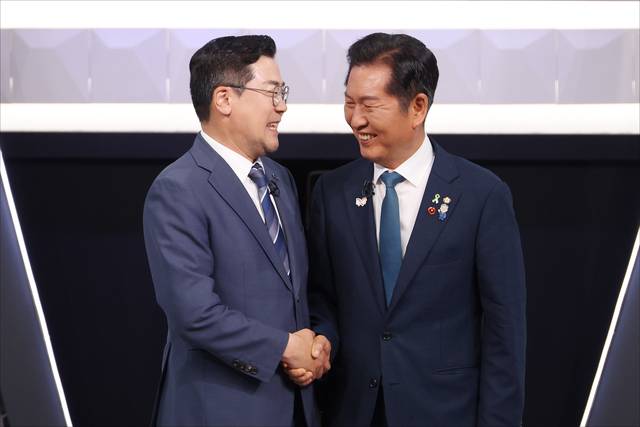 더불어민주당 대표 선거에 출마한 정청래(오른쪽)·박찬대 후보가 지난 27일 오후 서울 영등포구 여의도 KBS 신관 공개홀에서 2차 텔레비전 토론회 시작 전 악수를 하고 있다. [국회사진기자단]