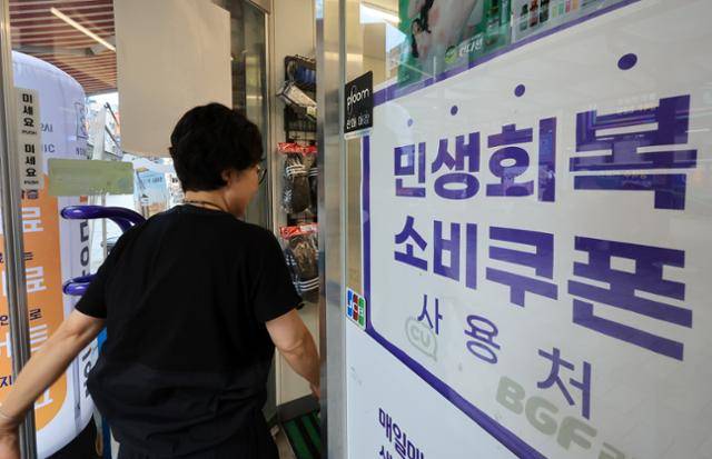 한 시민이 24일 민생회복 소비쿠폰 사용이 가능하다는 안내문이 붙어 있는 서울 시내 한 편의점으로 들어서고 있다. 뉴스1