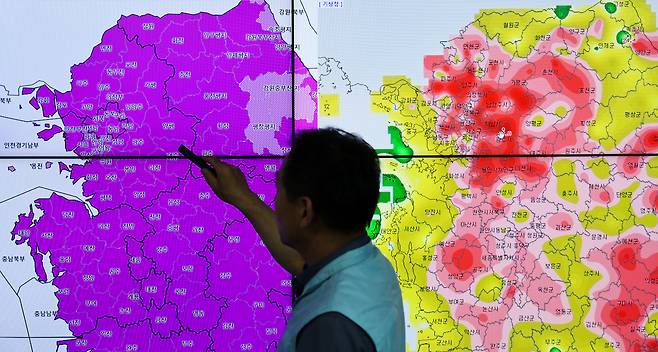 A forecaster at the Korea Meteorological Administration's metropolitan branch in Suwon, Gyeonggi, shows the heat wave warning situation and the highest temperature in the metropolitan area on July 28. [WOO SANG-JO]