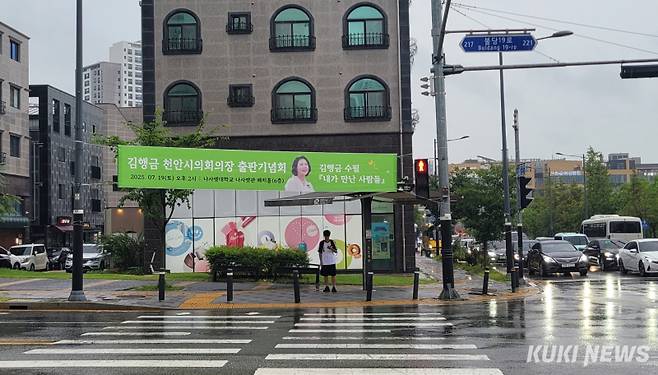 지난 17일 집중호우가 쏟아진 천안 불당동 한 네거리에 김행금 의장의 출판기념회 현수막이 걸려 있다. &nbsp;조한필 기자