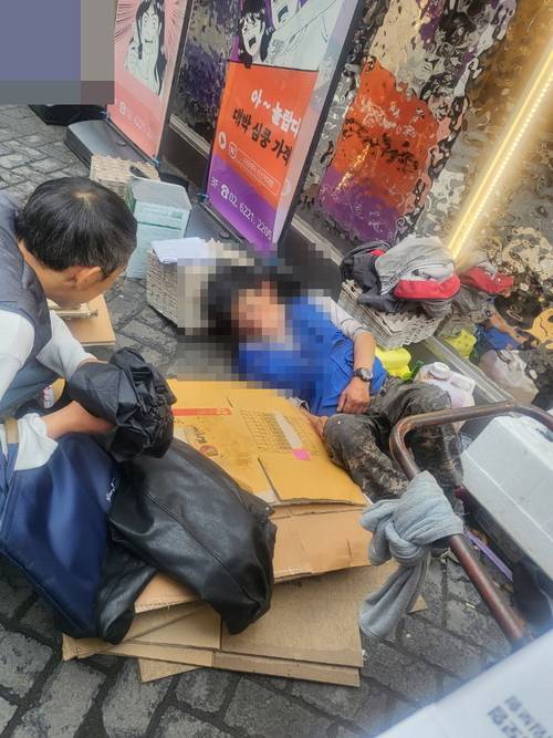 성북구 동선동주민센터 관계자가 거처 없이 길거리에 누워있는 A 씨를 설득하고 있다. 성북구청 제공