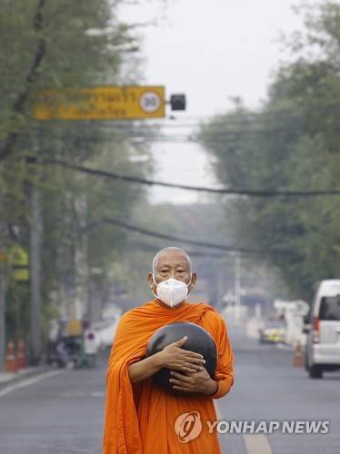 태국 방콕의 한 승려가 미세먼지 때문에 마스크를 쓰고 탁발을 하고 있다. 2023년 4월 17일, 태국은 산불과 광범위한 농작물 방화로 미세먼지 농도가 위험 수준을 기록했다. [EPA=연합뉴스]