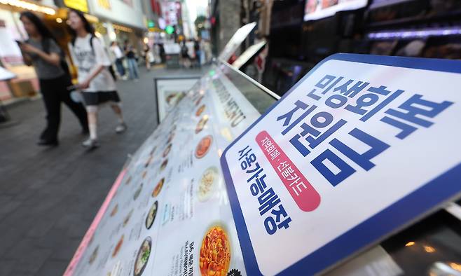지난 24일 서울 시내 한 음식점 메뉴판에 민생회복 지원금 안내문이 붙어 있다. 연합뉴스