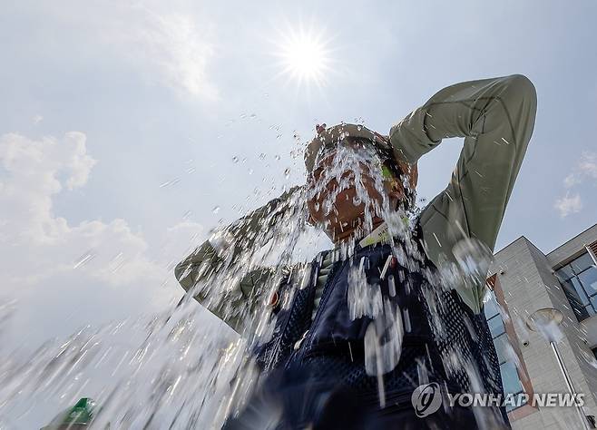 '더위야, 가라!' (서울=연합뉴스) 김도훈 기자 = 29일 서울 종로구 국정기획위원회 앞에서 열린 민주노총 건설노조 폭염 실태 기자회견이 끝난 뒤 참가자가 얼음물을 뒤집어쓰는 퍼포먼스를 하고 있다. 2025.7.29 superdoo82@yna.co.kr