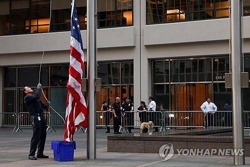 뉴욕 총기 난사 건물 앞에서 조기 게양하는 남성 [로이터 연합뉴스 자료사진. 재판매 및 DB 금지]