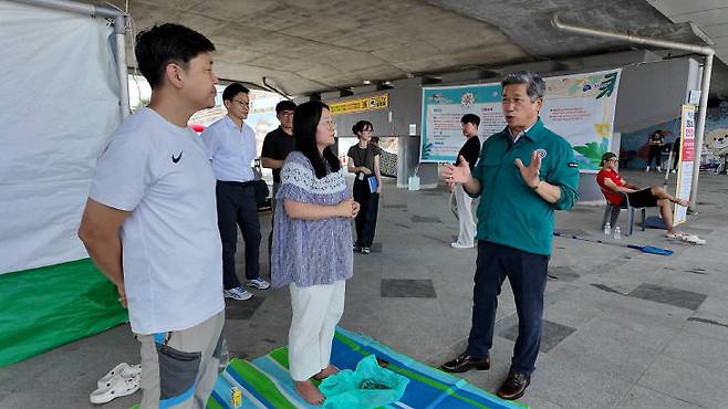 이재명 진천군의회 의장이 어린이 물놀이장을 찾아 관계자들은 격려하고 있디.