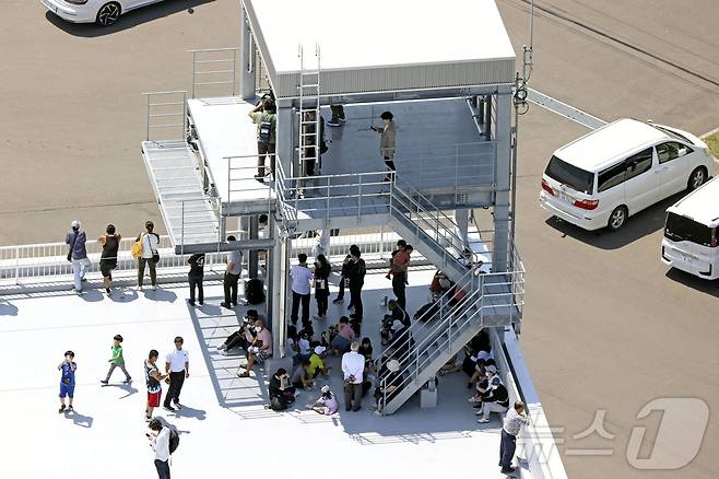 30일 러시아 캄차카 반도에서 발생한 대지진으로 일본 홋카이도 무카와에 쓰나미 경보가 발령되자 소방서 건물 옥상으로 사람들이 대피해 있다. / 뉴스1 ⓒ News1 2025.7.30 ⓒ 로이터=뉴스1 ⓒ News1 강민경 기자