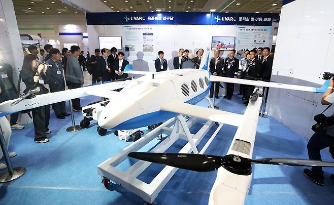 지난해 7월 서울 강남구 코엑스에서 막을 올린 ‘2024 무인이동체산업엑스포’(2024 UWC)에서 내빈과 관람객들이 한국항공우주연구원 부스에서 육공 분리합체형 배송용 무인 이동체를 살펴보고 있다. /뉴스1