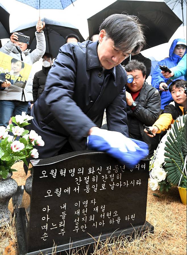 조국 전 법무부 장관이 신당 창당을 앞두고 지난해 2월14일 국립5·18민주묘지를 찾아 고 정동년 전 5·18기념재단 이사장의 묘비를 닦고 있다. 이명자 전 오월어머니집 관장 제공