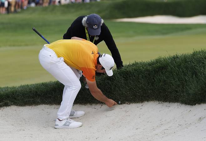 <yonhap photo-2808=""> epa10645113 Viktor Hovland of Norway (R) and a rules official (L) look over Hovland's plugged ball in the face of the sand trap along the 16th fairway during the final round of the 2023 PGA Championship golf tournament at the Oak Hill Country Club in Rochester, New York, USA, 21 May 2023. EPA/CJ GUNTHER/2023-05-22 09:05:29/ <저작권자 ⓒ 1980-2023 ㈜연합뉴스. 무단 전재 재배포 금지.></yonhap>