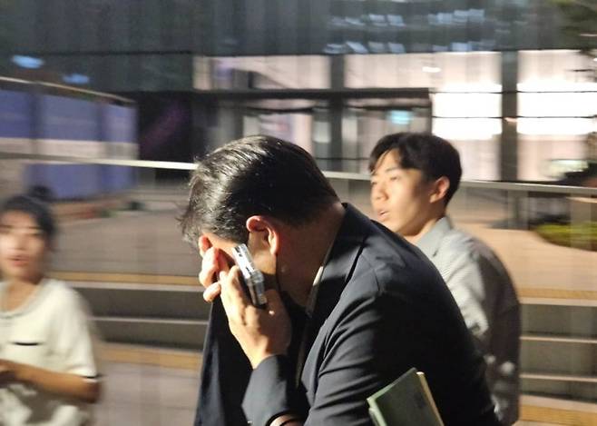 김건희 여사 오빠인 김진우 씨가 28일 김 여사 관련 의혹들을 수사하는 민중기 특별검사팀 사무실이 위치한 서울 종로구 KT광화문빌딩에서 조사를 마친 뒤 얼굴을 가린 채 특검 사무실을 나서고 있다. 사진=연합뉴스
