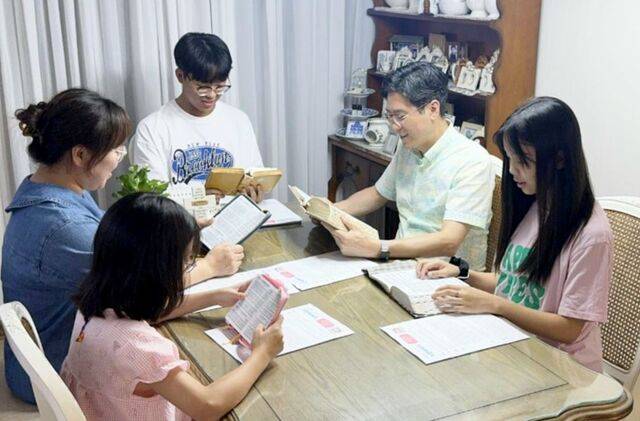 광주동명교회 출석 가정이 식탁에 둘러앉아 성경 읽기와 가정 예배를 드리는 장면. 광주동명교회 제공