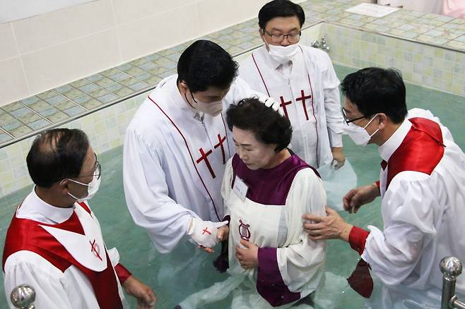 지난해 열린 침례식에서 한 성도가 담임목사와 집례자들의 인도로 침례를 받기 직전 기도하는 모습.  전주 순복음참사랑교회 제공