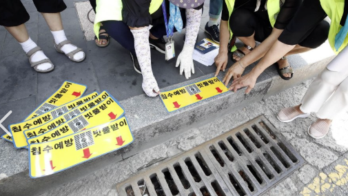 환경부 공무원이 침수 취약 지구 빗물받이 위에 스티커를 부착하고 있는 모습. 연합뉴스