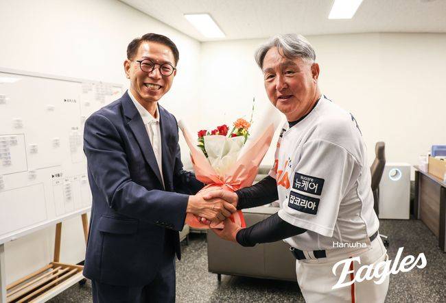 한화 김경문 감독(오른쪽)이 박종태 대표이사로부터 부임 100승 기념 축하 꽃다발을 받고 있다. /한화 이글스 제공