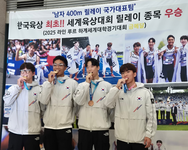 한국 남자 육상 400m 계주 대표팀이 29일 인천국제공한 1터미널 입구장에서 열린 귀국 환영식에서 금메달을 깨물며 포즈를 취하고 있다. (왼쪽부터) 서민준, 나마디 조엘진, 이재성, 김정윤. 영종도 박성국 기자