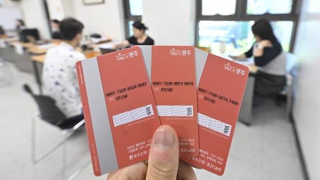 광주시가 민생회복 소비쿠폰 선불카드를 소득에 따라 색상을 달리해 논란을 빚은 지 9일 만에 분홍색으로 통일된 신규 카드 지급에 나섰다. 사진은 31일 오전 광주 남구 진월동행정복지센터에서 시민들이 새롭게 제작된 소비쿠폰 선불카드를 발급받는 모습./김애리 기자·조영권 인턴기자