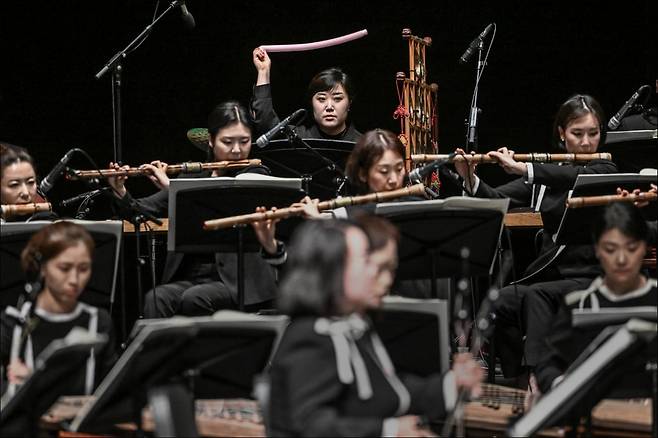 지난 6월 26일 세종문화회관에서 열린 공연 <장단의 재발견>의 연주 장면. 무대 뒤편 가운데에 있는 한 연주자가 장난감 같이 생긴 기다란 악기를 돌리며 바람 소리를 내고 있다. / 사진출처. 세종문화회관.