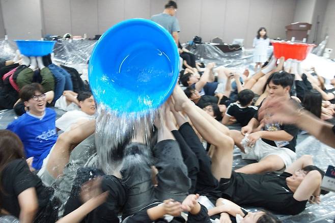 호산나교회 고등부 3학년들이 지난 27일 경주 켄싱턴리조트에서 열린 여름 수련회 공동체 프로그램에서 물을 채운 양동이를 발로 드는 게임에서 물이 쏟아져 옷이 흠뻑 젖은 채 즐거워하고 있다.