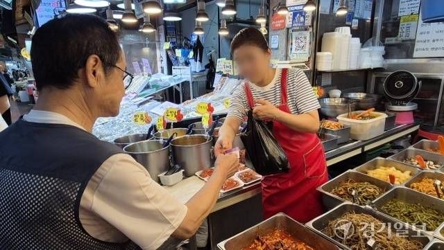 30일 수원 못골종합시장에서 한 시민이 장을 보고 신용카드를 내밀고 있다. 이진기자