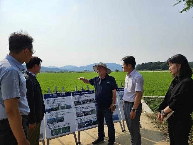 지난 8일 김식(가운데) 지금강이엔지 회장이 전남 나주시 동강면 들녘에서 김병원 전 농협회장 등 농업관계자들에게 대형화된 첨단농지 설명회를 갖고 있다. 지금강이엔지 제공