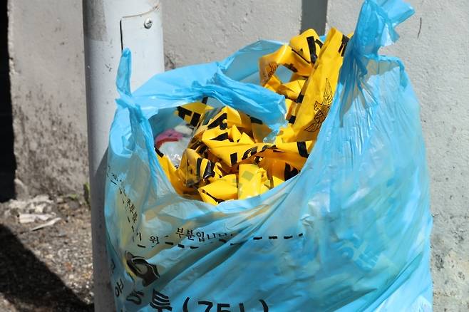 지난 29일 낮 12시 8분쯤 대전 서구 괴정동 주택가에서 한 남성이 30대 여성을 흉기로 찌르고 도주했다. 경찰은 피해 여성의 전 연인으로 추정되는 20대 남성 용의자를 하루 만에 검거했다. 사진은 현장에 쳐놨던 경찰 통제선이 쓰레기봉투에 버려져 있는 모습. 대전 연합뉴스