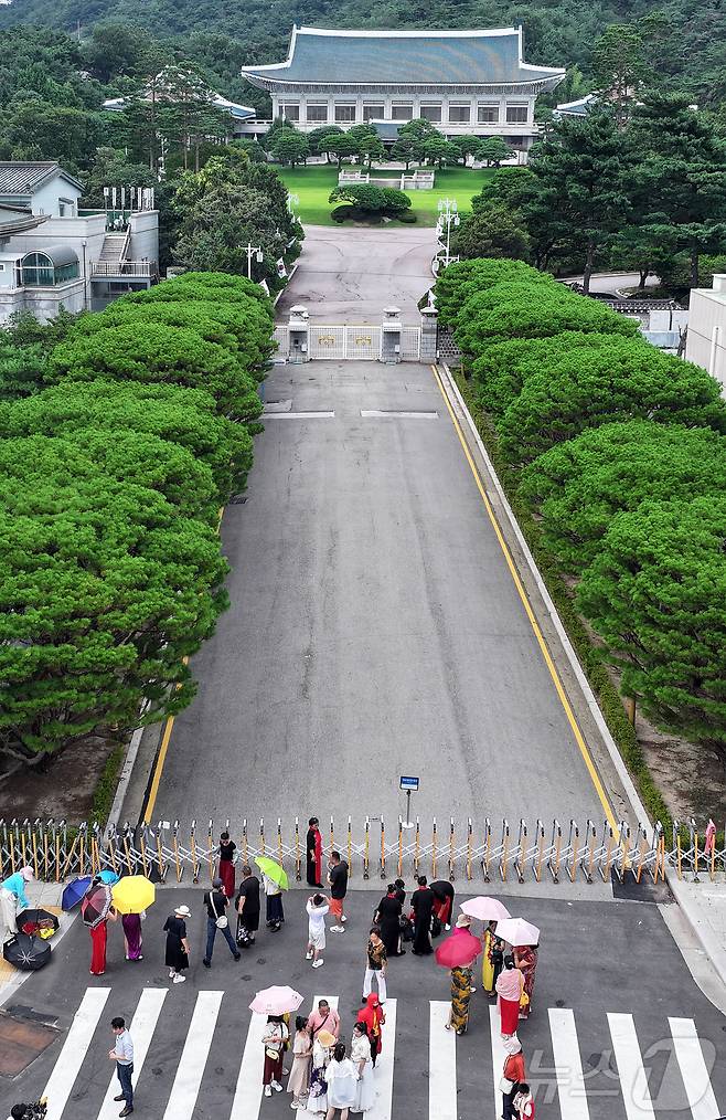 이재명 대통령이 청와대로 집무실 복귀를 예고한 가운데 오는 8월 1일부터 보안·안전 점검 등 준비작업을 위해 관람이 임시 중단된다. 사진은 31일 서울 종로구 세종로 청와대 정문 앞에서 관광객들이 추억을 남기고 있다. 2025.7.30/뉴스1 ⓒ News1 김진환 기자