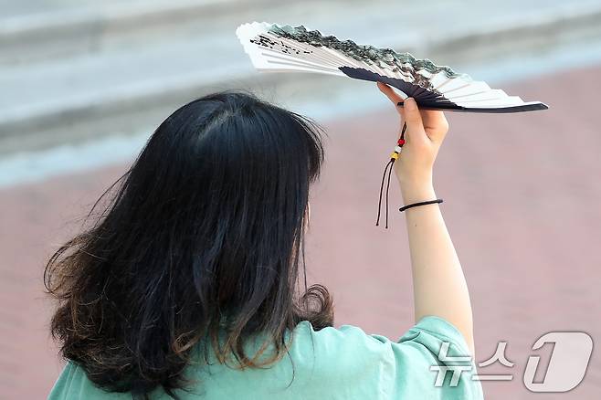폭염이 계속된 1일 대구 중구 동성로에서 한 시민이 부채로 뙤약볕을 가린 채 발걸음을 옮기고 있다. 2025.8.1/뉴스1 ⓒ News1 공정식 기자