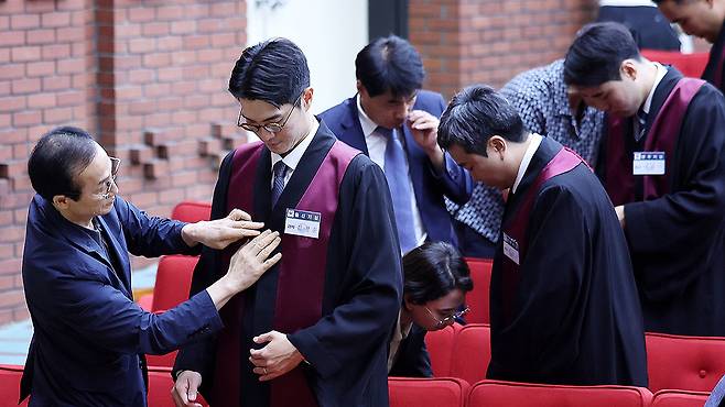 부모님들이 신임 검사들에게 법복을 입혀주고 있다. 뉴스1