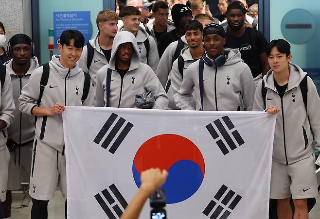 1일 인천공항을 통해 입국한 토트넘 손흥민(왼쪽 둘째)과 양민혁(오른쪽)이 태극기를 들고 나와 양쪽 끝을 나눠 잡고 펼쳐 보였다. [연합뉴스]
