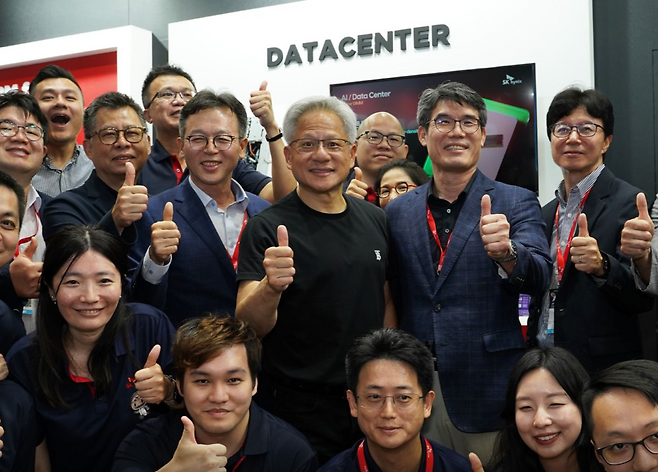 젠슨 황 엔비디아 최고경영자(CEO)가 지난 5월 20일 대만 타이베이에서 열린 IT 전시회 ‘컴퓨텍스 2025’에서 SK하이닉스 부스를 깜짝 방문해 임직원들과 기념촬영하고 있다. [SK하이닉스 SNS]