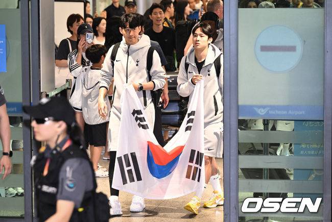 [OSEN=인천공항, 조은정 기자]토트넘 선수단이 1일 오후 인천국제공항을 통해 입국했다. 토트넘은 오는 3일 서울월드컵경기장에서 뉴캐슬(잉글랜드)과 2025 쿠팡플레이 시리즈 2경기를 치른다.토트넘 손흥민, 양민혁이 태극기를 들고 입국장을 나서고 있다.2025.08.01 /cej@osen.co.kr