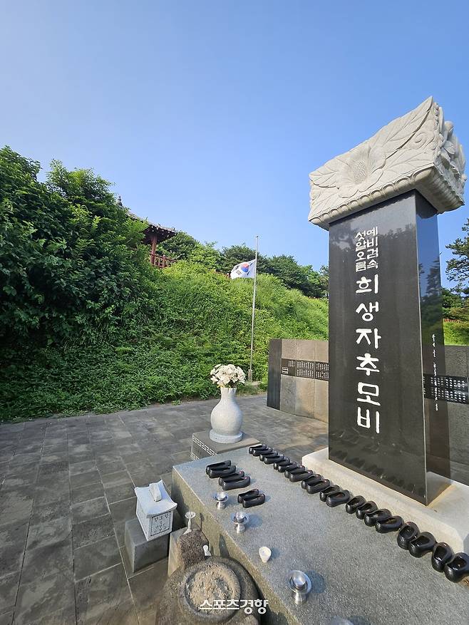 섯알오름 학살 추모비. 고무신이 가슴을 저리게 한다. 게양된 태극기는 조기로 예를 갖췄다. 사진|강석봉 기자