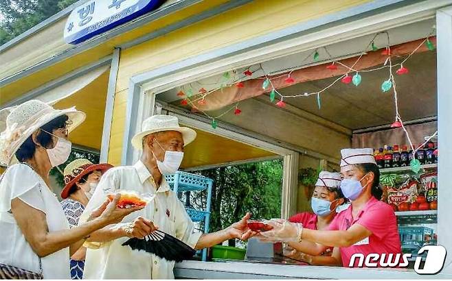 (평양 노동신문=뉴스1) = 북한 주민들이 한 상점에서 시원한 음료를 구매하고 있다. [국내에서만 사용가능. 재배포 금지. DB 금지. For Use Only in the Republic of Korea. Redistribution Prohibited] rodongphoto@news1.kr