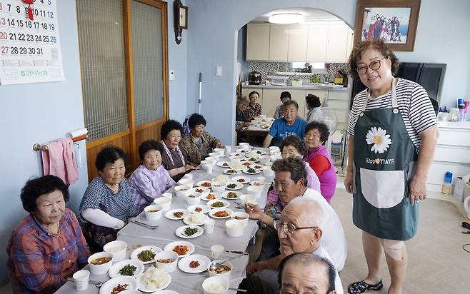 어르신들을 위해 점심을 준비한 박정래 씨(67)가 임시 마을회관에서 어르신들과 함께 활짝 웃고 있다. 노인회장이 남편인 박 씨는 울산이 집이지만 산불 이후로 이곳에 남아 어르신들의 점심을 책임지고 있다. 전민규 기자
