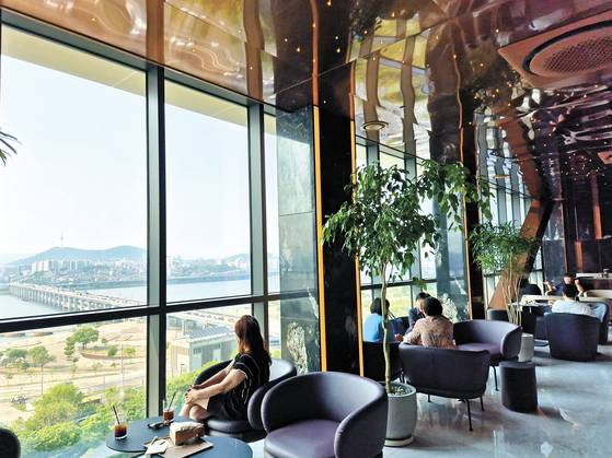 A cafe in the Raemian One Bailey apartment complex in the posh Seocho District in southern Seoul. The Han River is seen out the window. [JOONGANG ILBO]