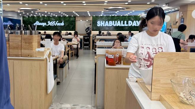 A customer helps herself at Shabu Allday on July 24. [WOO JI-WON]