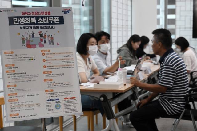 민생 경제 회복을 위한 ‘민생회복 소비쿠폰’ 신청이 시작된 21일 서울 성동구 옥수동 주민센터에 마련된 접수처에서 주민들이 소비쿠폰을 신청하고 있다. 조태형 기자 2025.07.21