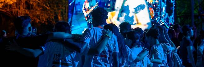 관객들이 하나둘 모이더니 어깨를 잡고 노래에 맞춰 원을 그렸다