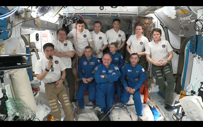 국제우주정거장(ISS)의 제73차 탐사대원 7명(하얀 옷) 크루-11의 승무원 4명(앞줄 파란 옷)을 환영하고 있다. NASA 유튜브 캡처