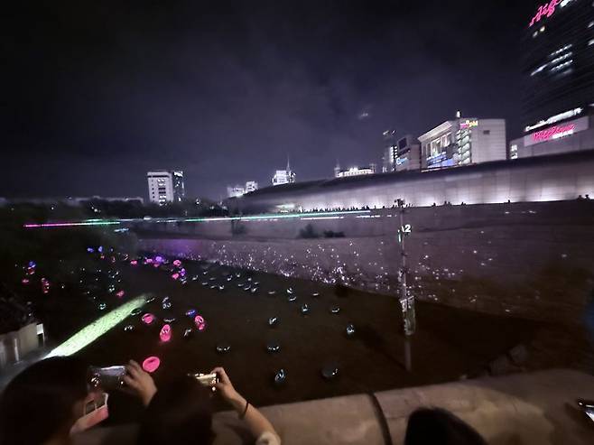 지난 7월 31일 서울 중구의 동대문디자인플라자 이간수문 위쪽 둘레길에 시민들이 모여 미디어 아트를 관람하고 있다. 이창훈 기자