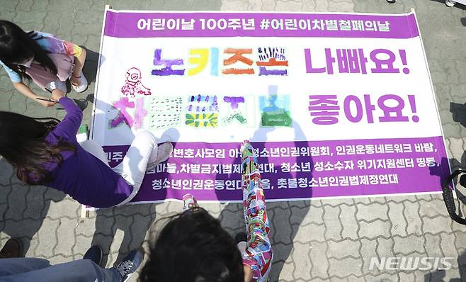 [서울=뉴시스] 최진석 기자 = 어린이들이 지난 2022년 5월 4일 서울 영등포 국회 앞에서 열린 '어린이날 100주년, 어린이차별철폐의 날 선포 기자회견'에 참석해 '노키즈존 나빠요!, 차별금지법 좋아요!' 문구에 색칠하는 퍼포먼스를 하고 있다. 2022.05.04. myjs@newsis.com
