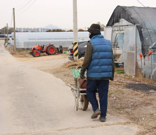 한 이주노동자가 농기구를 옮기고 있다. 연합뉴스