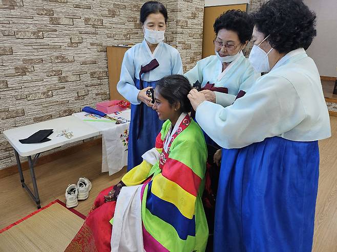추석 명절을 맞아 전통 체험행사에 참석한 외국인주민이 한복을 입고 댕기머리 땋기 체험을 하고 있다.